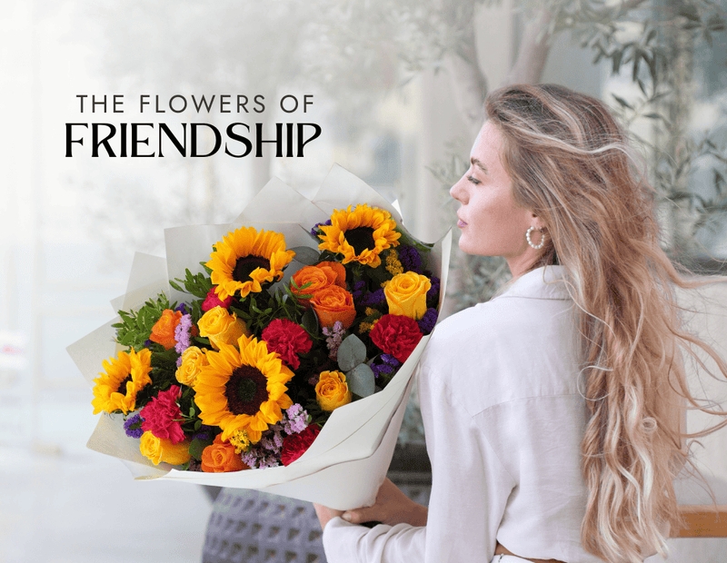 Woman holding a large bouquet of sunflowers, orange roses, and mixed flowers from Flowers.ie