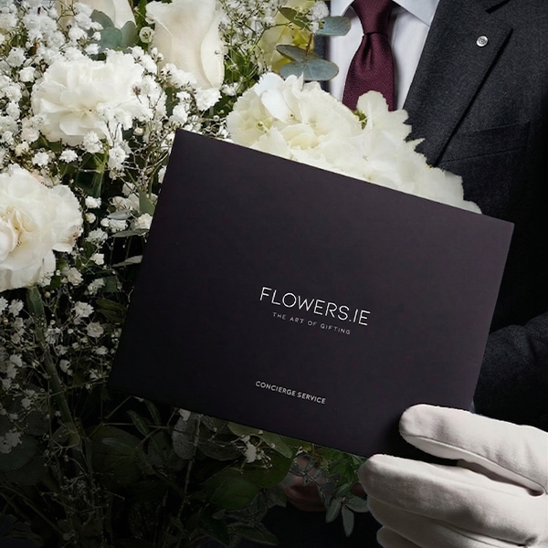 Flowers.ie concierge holding a luxury branded presentation box with white floral arrangement