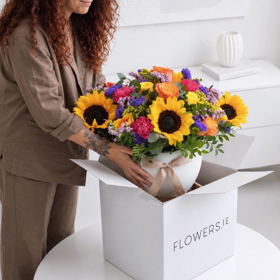 Carefully unbox and lift the flower arrangement