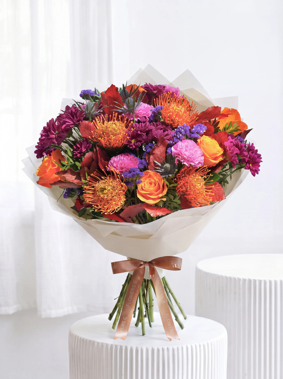 XL Amber Glow hand-tied bouquet of sunflowers, yellow and orange roses with blue and pink statice, Flowers.ie